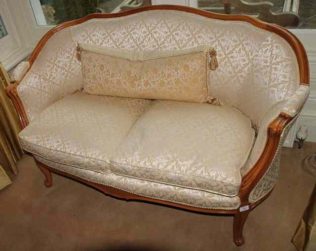 A FRENCH BEECHWOOD FRAMED SMALL SOFA with rounded back scrolling