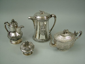 A Middle Eastern white metal teapot and sugar basin with