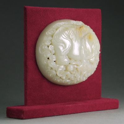The stone of light celadon color with brown skin carved