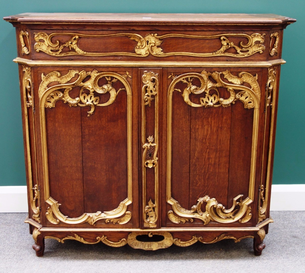A late 19th century continental parcel gilt oak side cabinet