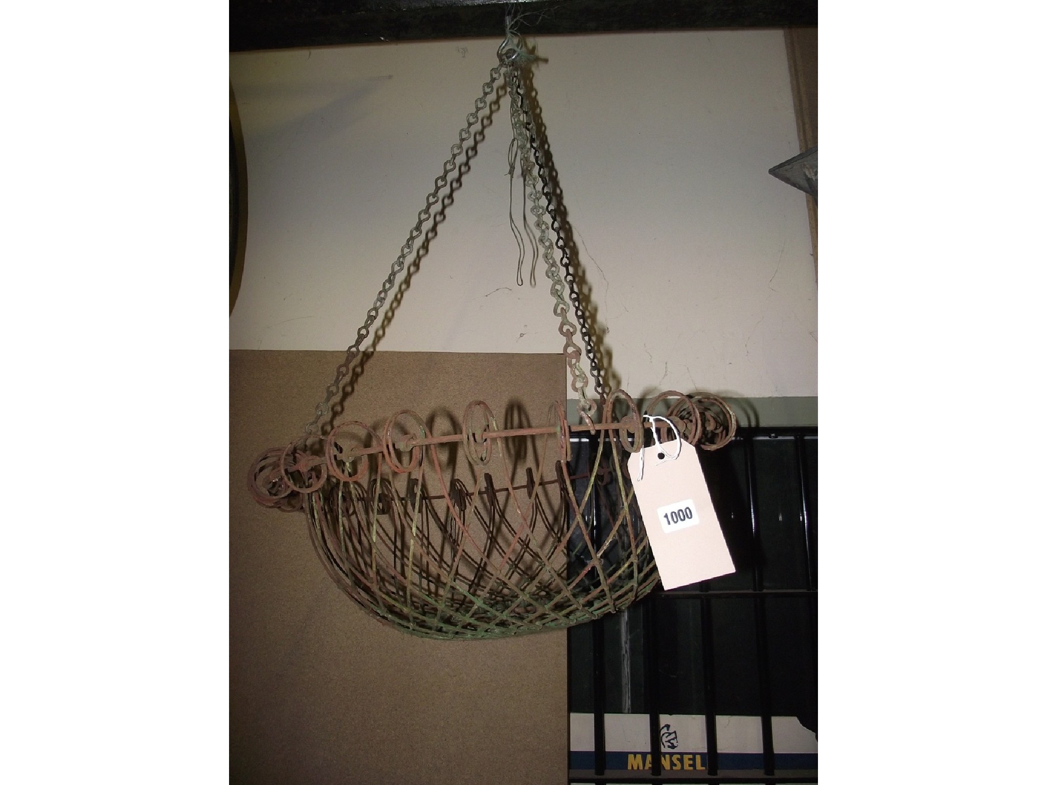 A vintage wirework hanging basket with lattice and simple scroll