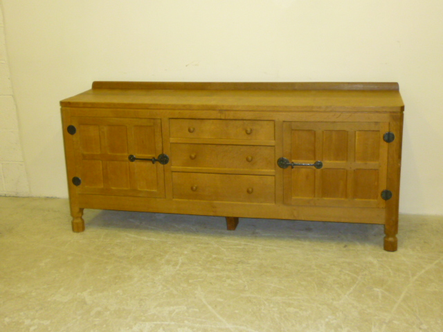 AN ADZED OAK SIDEBOARD by Robert Mouseman Thompson with ledge