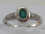 A white metal tests 18 carat gold emerald and diamond