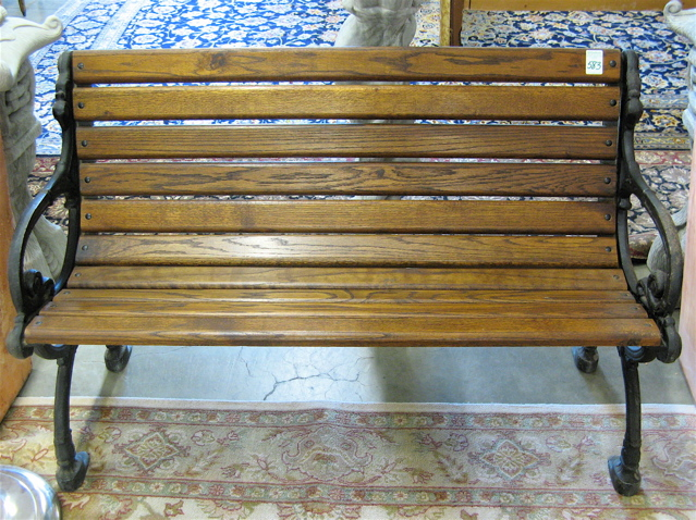 AN OAK AND CAST METAL PARK BENCH American 20th century
