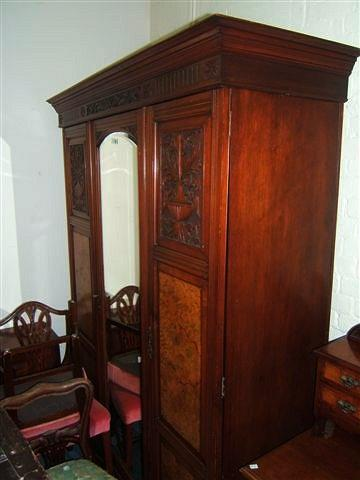 A Victorian walnut triple wardrobe with central mirrored door flanked