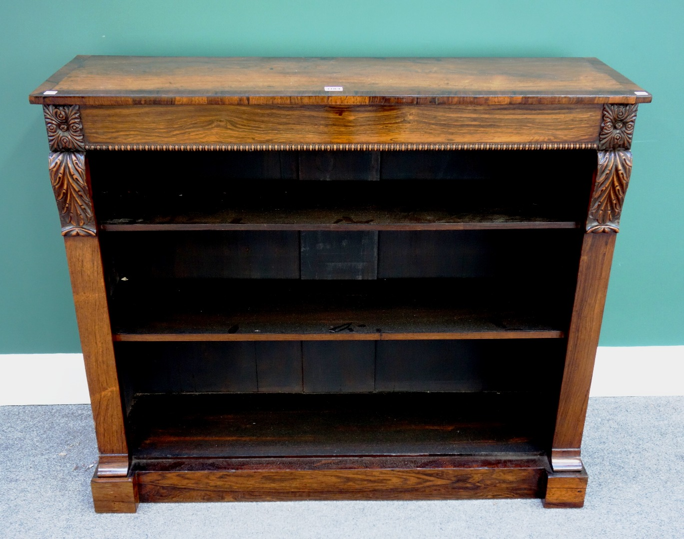 An early 19th century crossbanded rosewood floor standing open bookcase