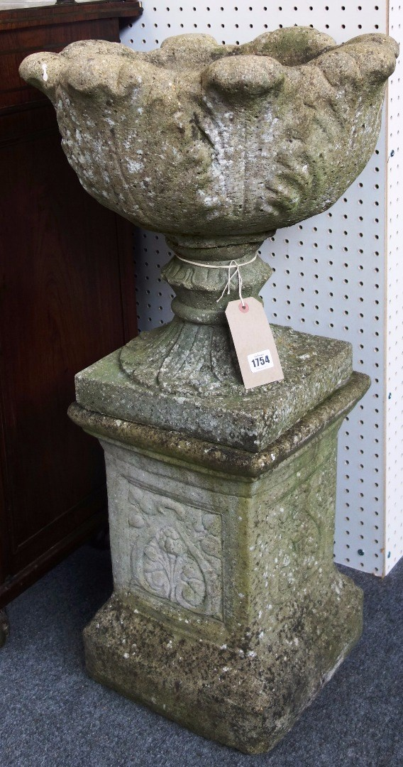 A pair of reconstituted stone jardinieres with leaf moulded bodies