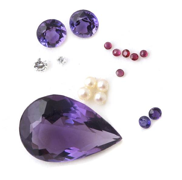 A group of unmounted stones including diamonds rubies amethyst and