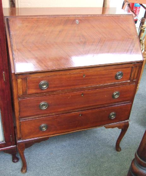 An Edwardian inlaid mahogany bureau the fall enclosing a fitted