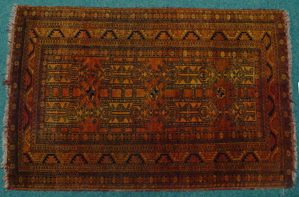 Rectangular orange and brown ground rug decorated with black geometric