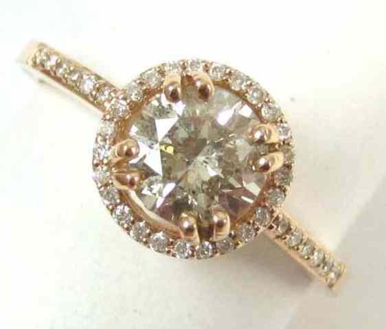 DIAMOND AND FOURTEEN KARAT ROSE GOLD RING featuring a round