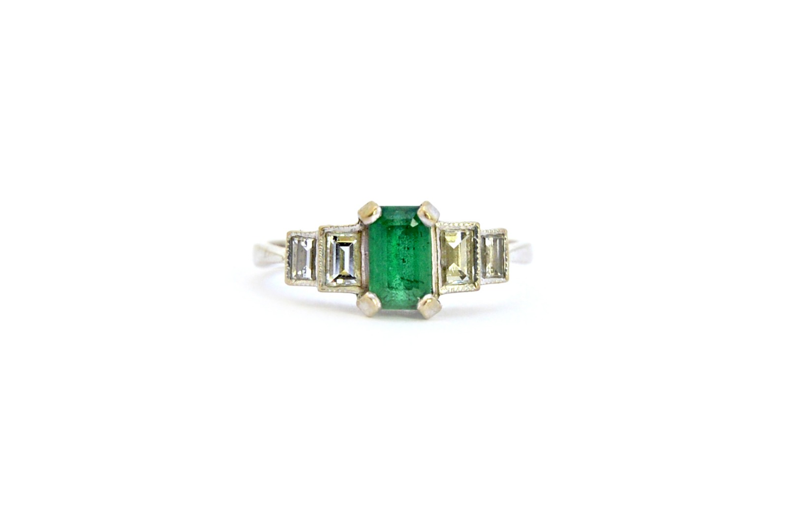 A white gold emerald and diamond ring claw set with