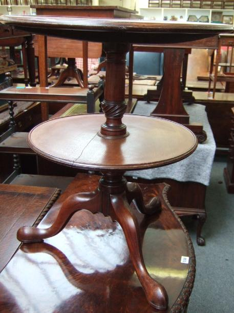 A 19th century mahogany two tier dumb waiter raised on