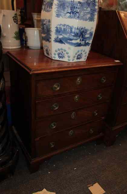 A VICTORIAN MAHOGANY SMALL CHEST of four drawers and ring