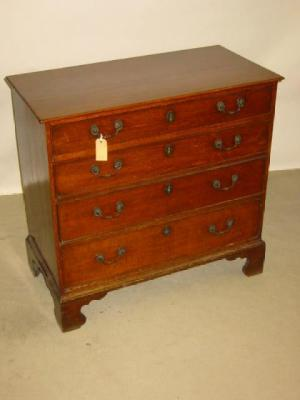 A GEORGE III OAK CHEST of four graduated cockbeaded drawers