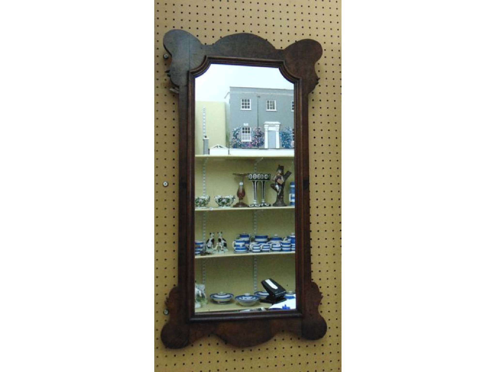 A burr walnut framed mirror of rectangular form with shaped