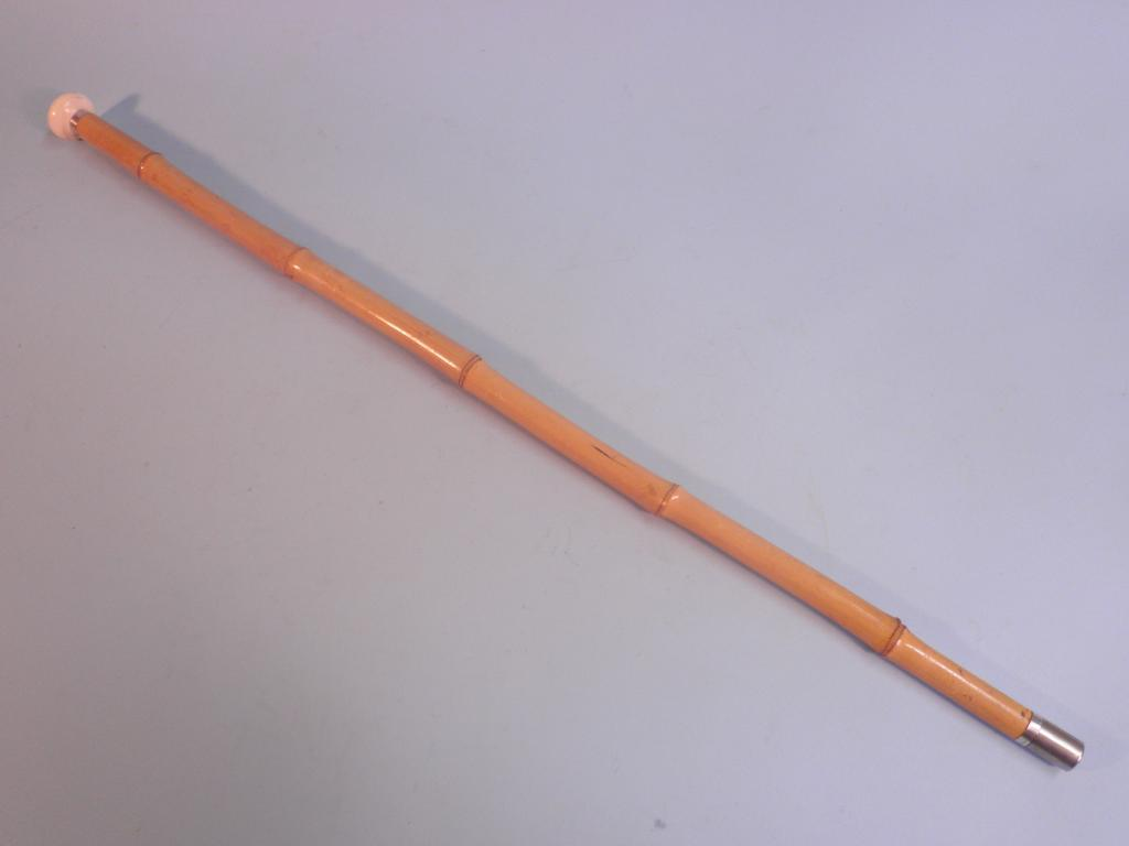 An early 20thC bamboo walking cane with sterling silver mount