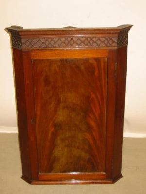 A GEORGE III MAHOGANY CORNER CUPBOARD the moulded and dentil