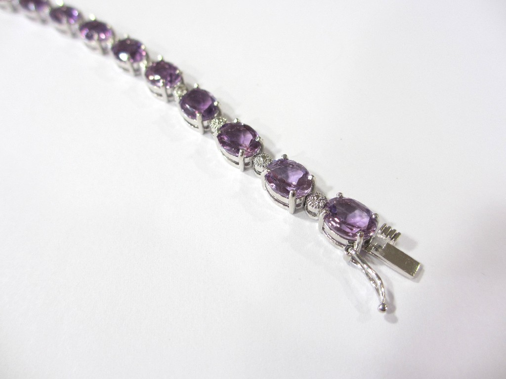 A silver and amethyst bracelet the articulated links set with