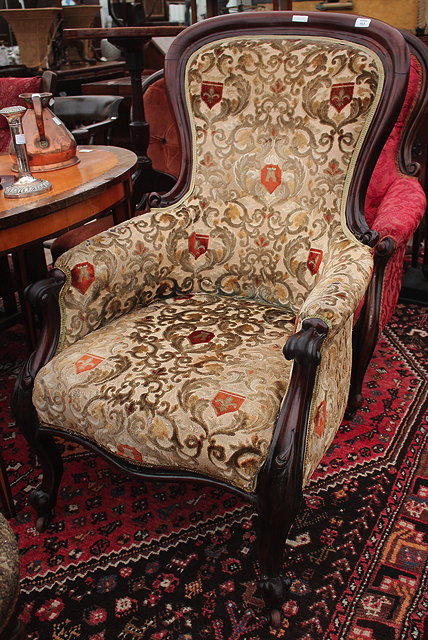A VICTORIAN MAHOGANY FRAMED LIBRARY ARMCHAIR with overstuffed upholstered serpentine