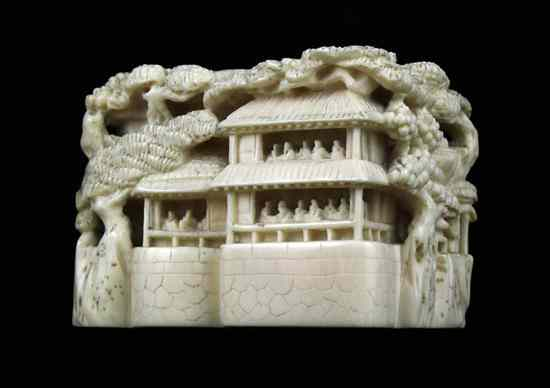 An Edo period ivory solid landscape netsuke carved with crowded