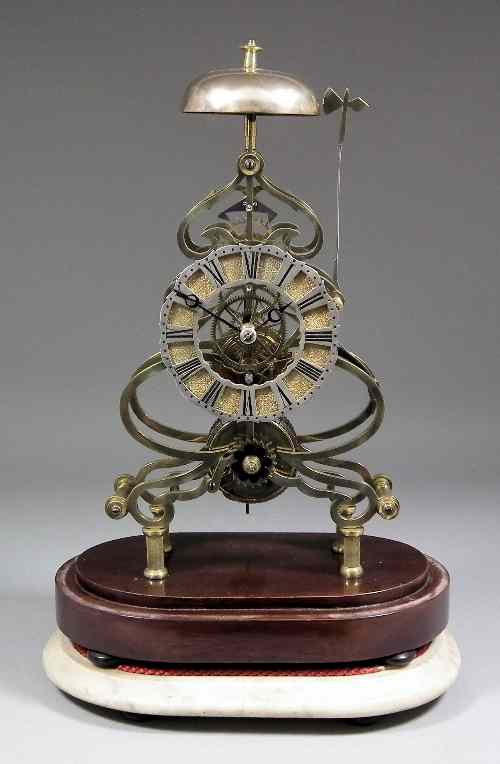 A brass framed Skeleton clock the 4 75ins diameter silvered