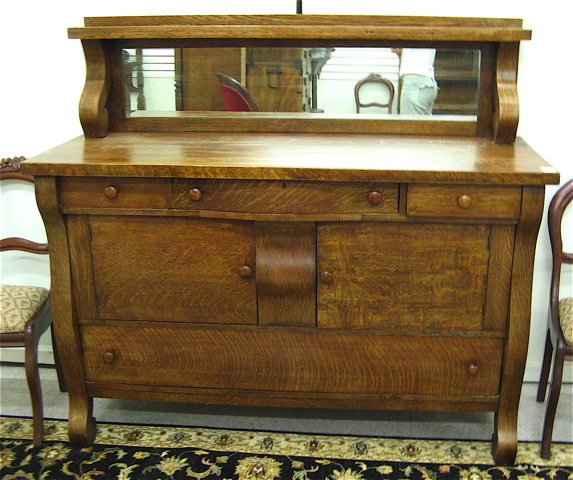 AN OAK EMPIRE REVIVAL SIDEBOARD American c 1910 having a