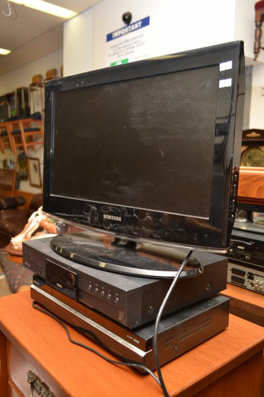 A SMALL SAMSUNG FLATSCREEN TV REMOTES IN OFFICE AND TWO