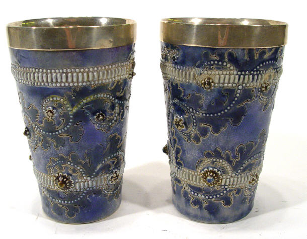Pair of Doulton Lambeth stoneware beakers with silver rims and