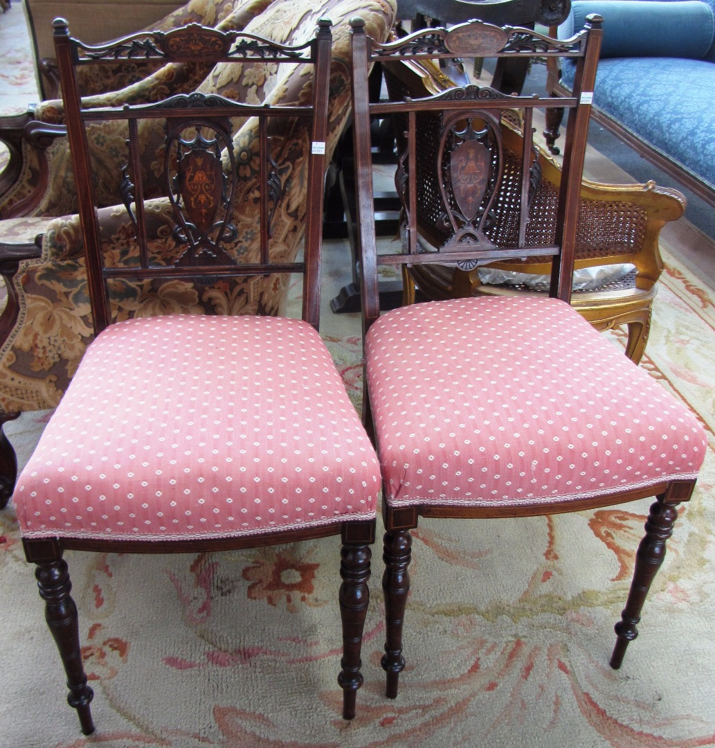 A pair of marquetry inlaid rosewood bedroom chairs with bow
