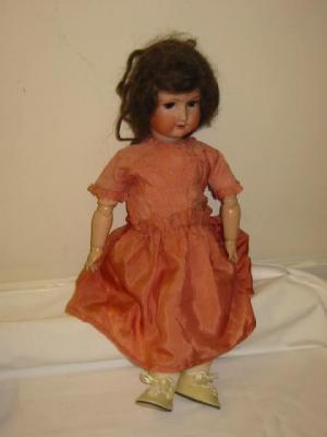 An Ernst Heubach bisque head girl doll with brown glass