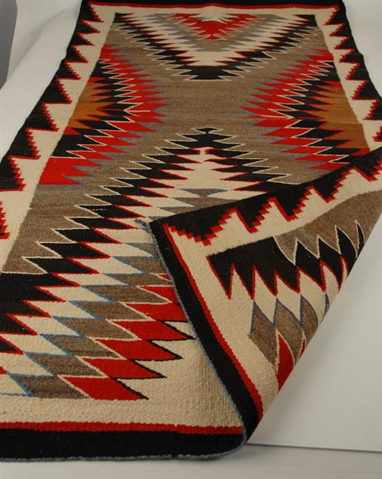 A Navajo Rug in a zigzag pattern in reds dark