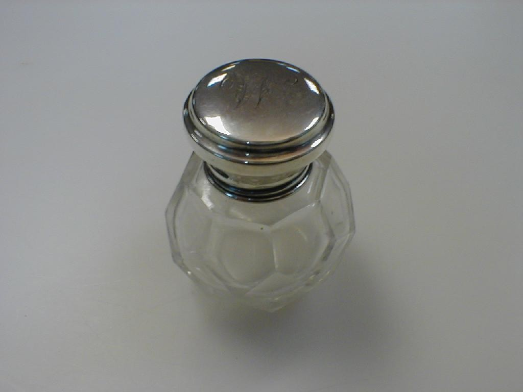 A small cut glass and silver perfume bottle faceted bottle