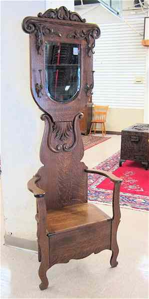 LATE VICTORIAN OAK HALLSTAND American c 1890 having an armchair