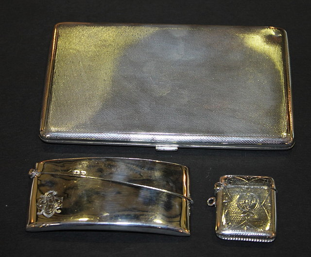 A SILVER CIGARETTE CASE with engine turned decoration and gilt