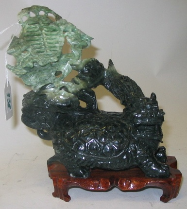 A CHINESE CARVED JADE FIGURE apple green shading to spinach