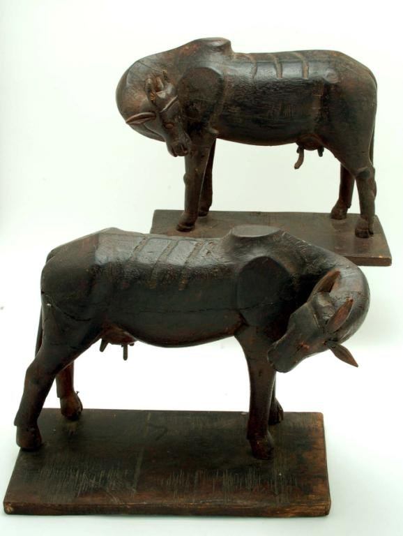 A pair of African wood carvings of wildebeests both rear