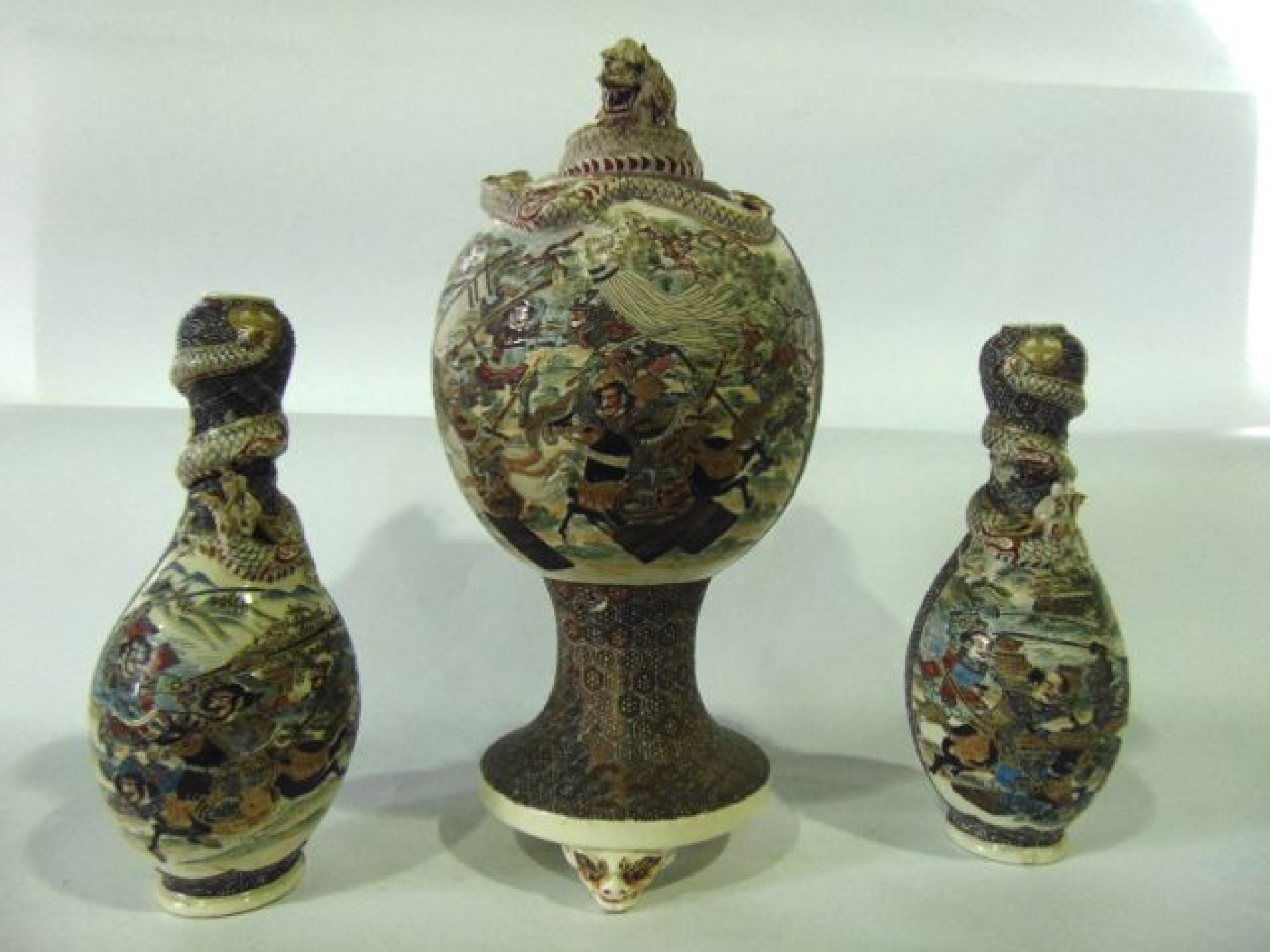 A late 19th century Satsuma garniture of three vases comprising