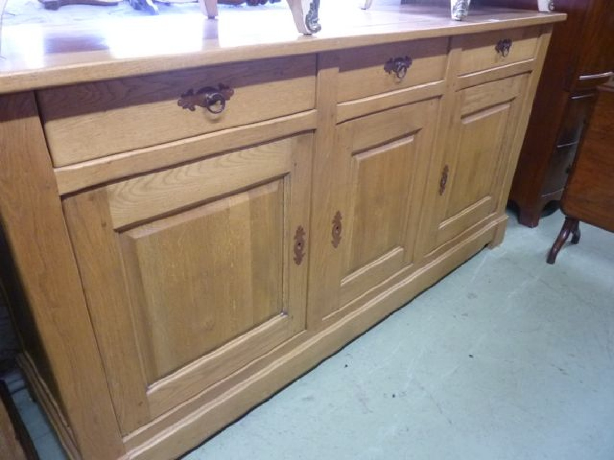 A contemporary medium to light oak dresser partially enclosed by