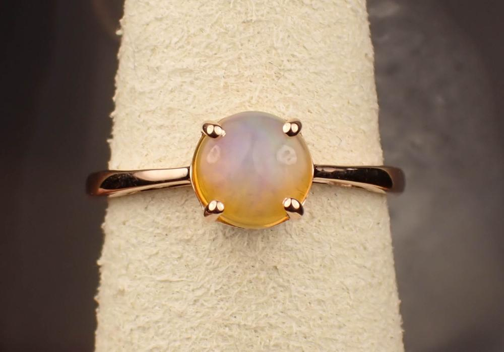 FIRE OPAL AND FOURTEEN KARAT ROSE GOLD RING with four