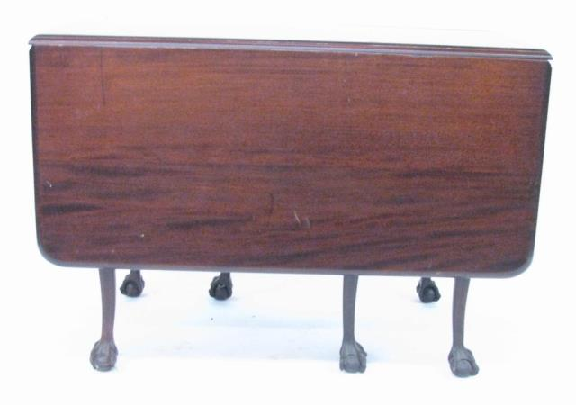 An antique mahogany rectangular drop leaf table double gate leg