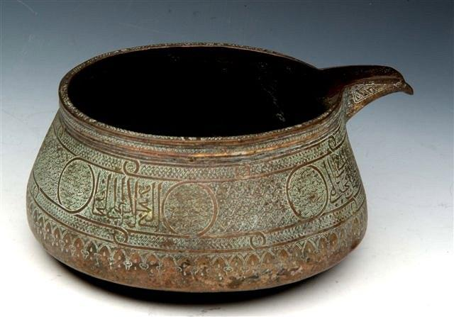A 17TH CENTURY PERSIAN SAFAVID CIRCULAR COPPER BOWL with spout