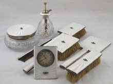 A dressing table set of eight pieces comprising three brushes