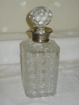 A CUT GLASS DECANTER of square form with flared moulded