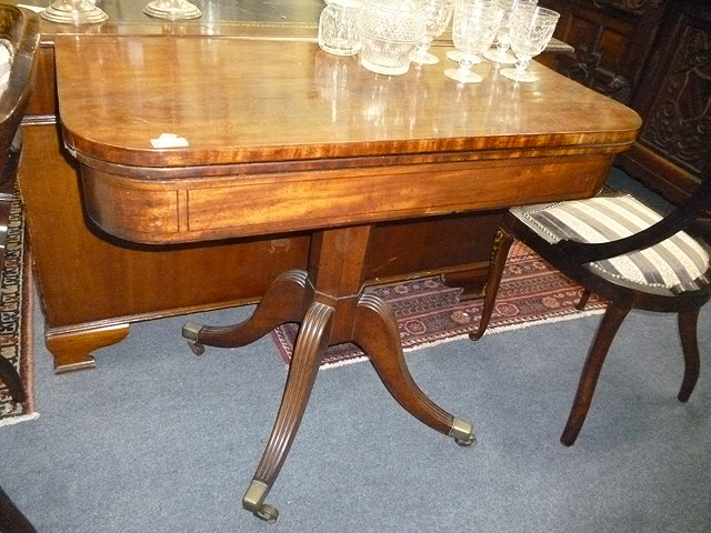 A VICTORIAN MAHOGANY FOLD OVER CARD TABLE standing on faceted