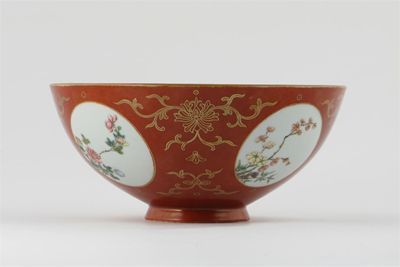 A Chinese coral ground bowl decorated with four famille rose