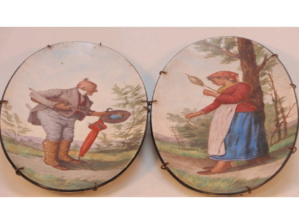 A pair of 19thC continental oval pottery plaques hand painted
