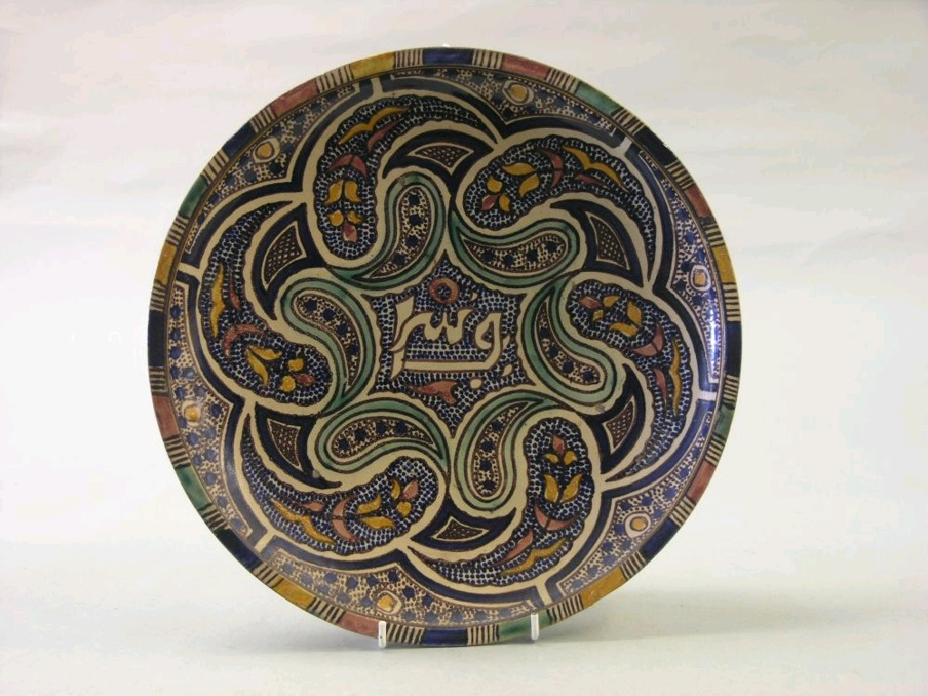 A Persian charger painted with a stylised floral design in