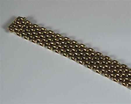 A modern 9ct gold bracelet of broad design composed of