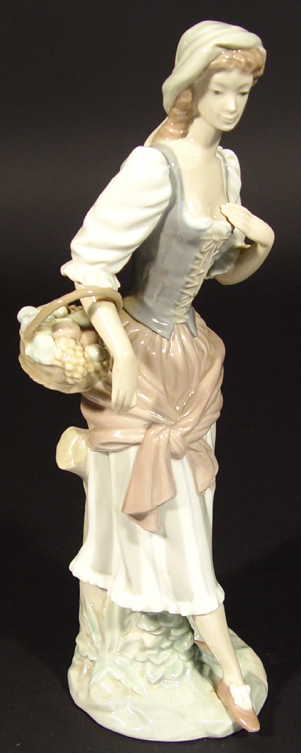 Lladro figurine clutching a basket of fruit with hand painted